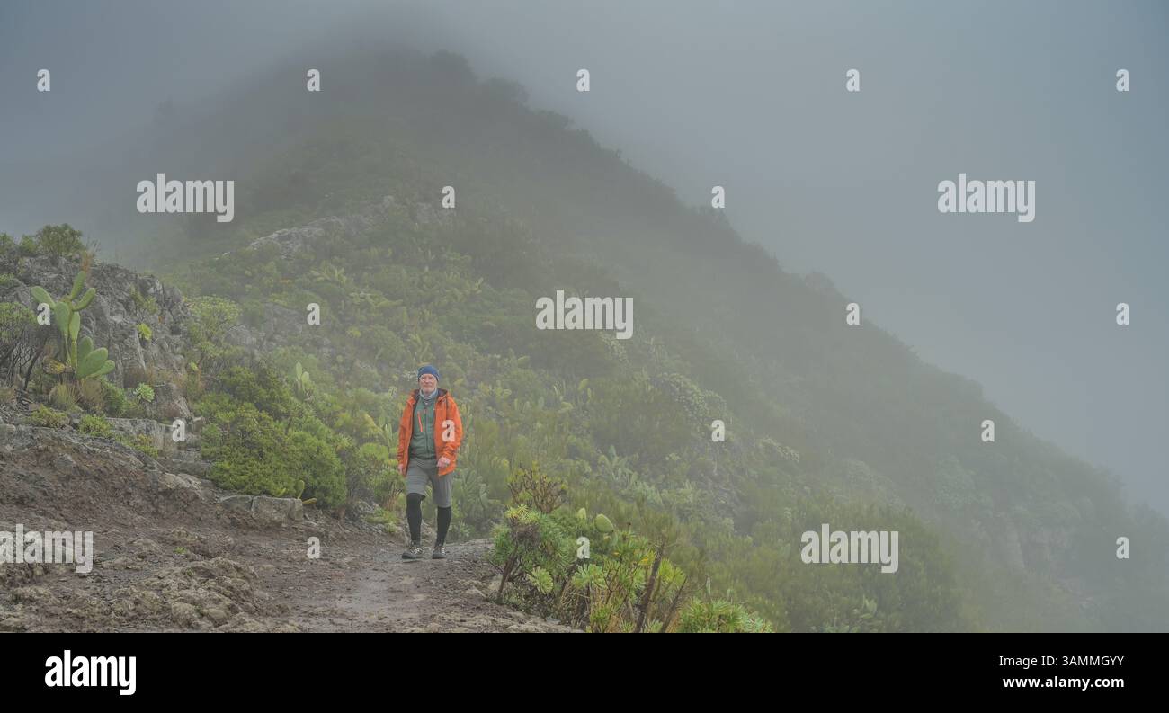 Wanderer im Nebel in den Bergen bei Masca, Teneriffa, Spanien Stock Photo
