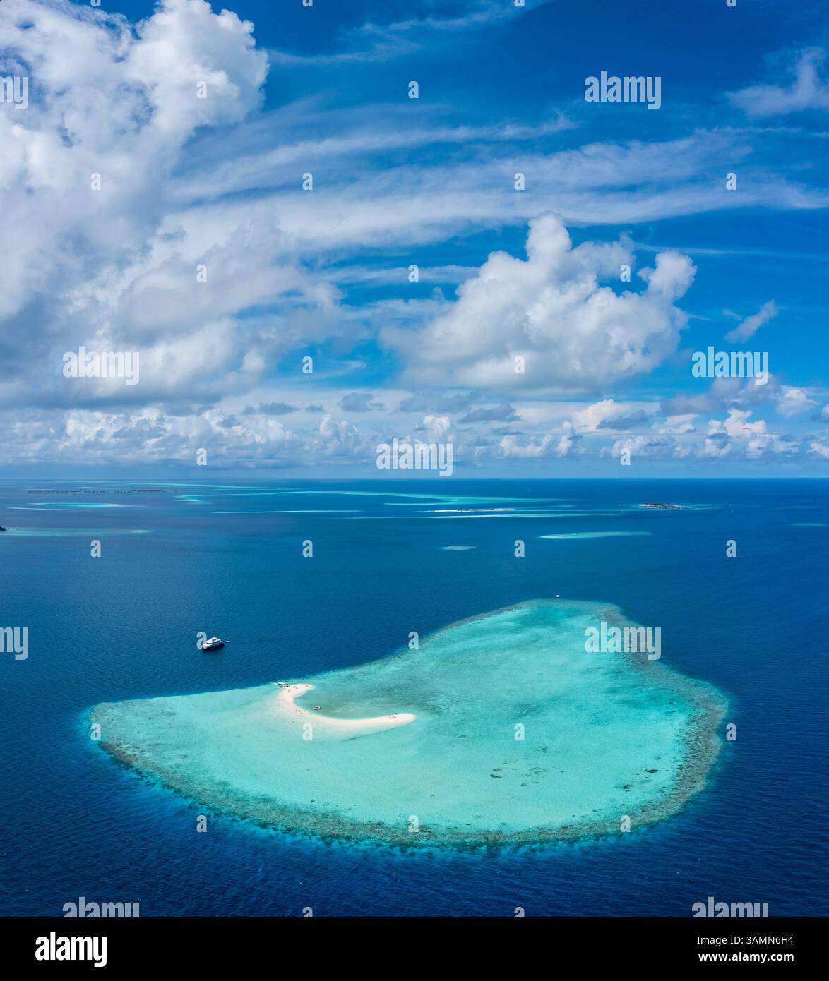 Aerial view of a boat along an Atoll with barrier Reef surrounded by ...
