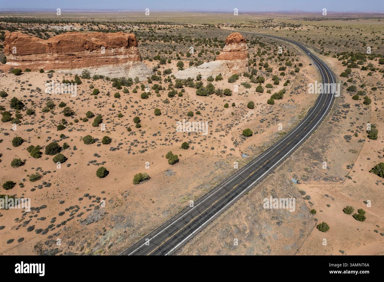 Aerial view of winding road through rugged desert landscape with ...