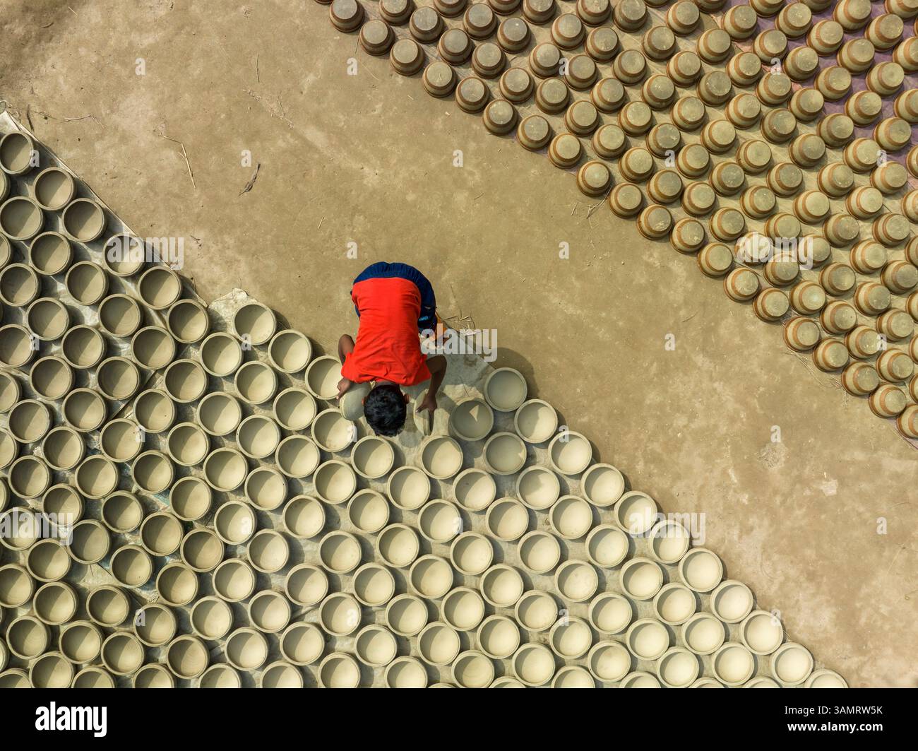 Aerial view of people working in a clay pot factory in Bogura ...