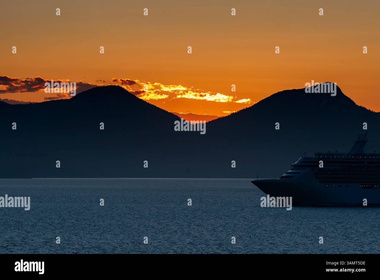 Evening skies and majestic mountain ranges on the Inside Passage in Alaska. Stock Photo