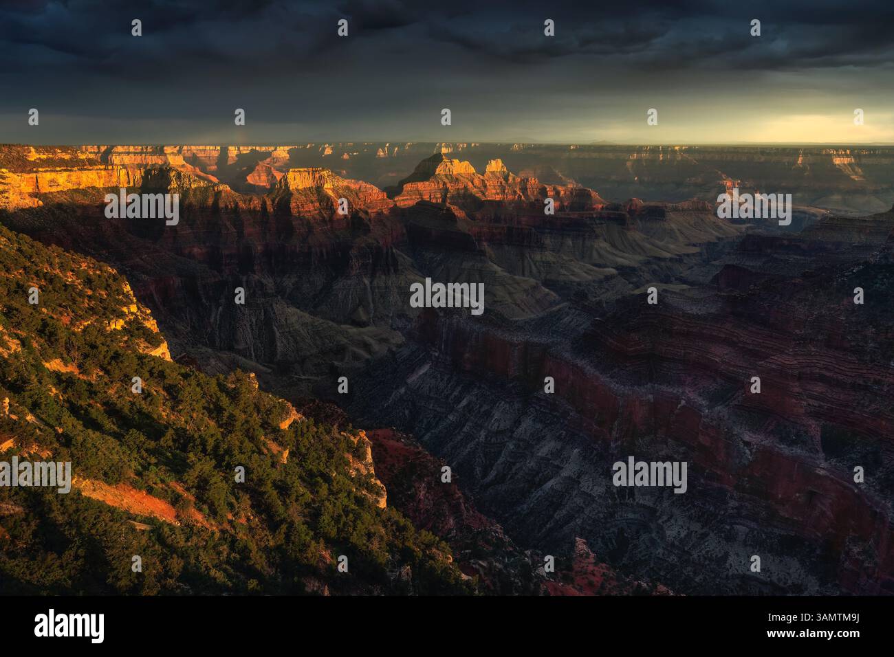 Aerial view of Grand Canyon at sunset with dramatic sky and rugged rock formations, Arizona, United States. Stock Photo