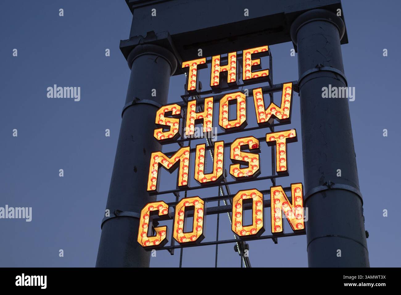 Neon sign 'The Show Must Go On' installed by The Stove Network over the Dumfries Suspension Bridge, inspired by the historic Rood Fair. Stock Photo