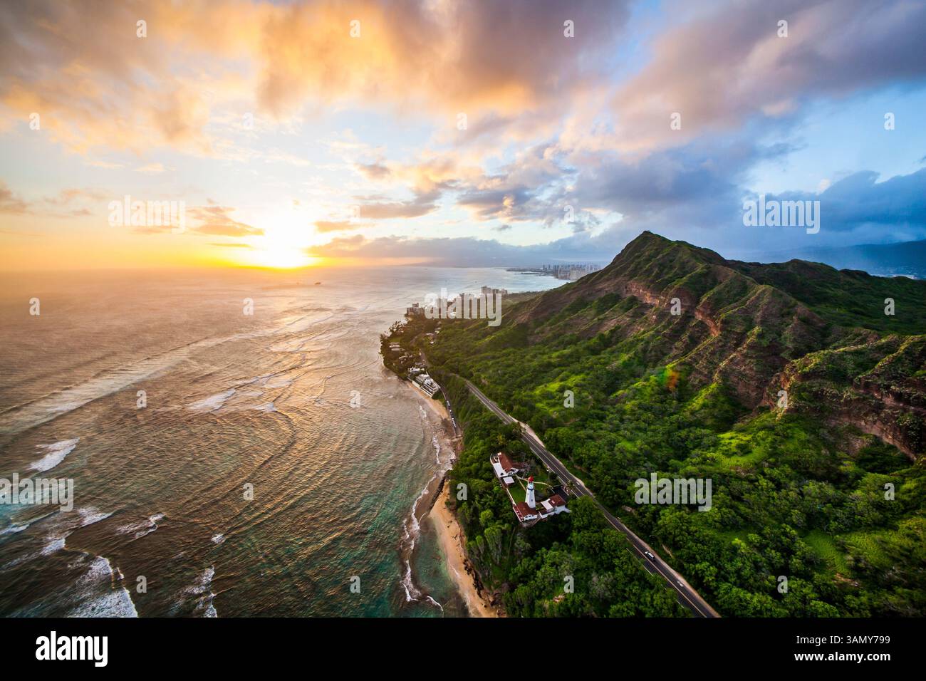 Aerial view of Diamond Head Lighthouse at sunset with waves and beach