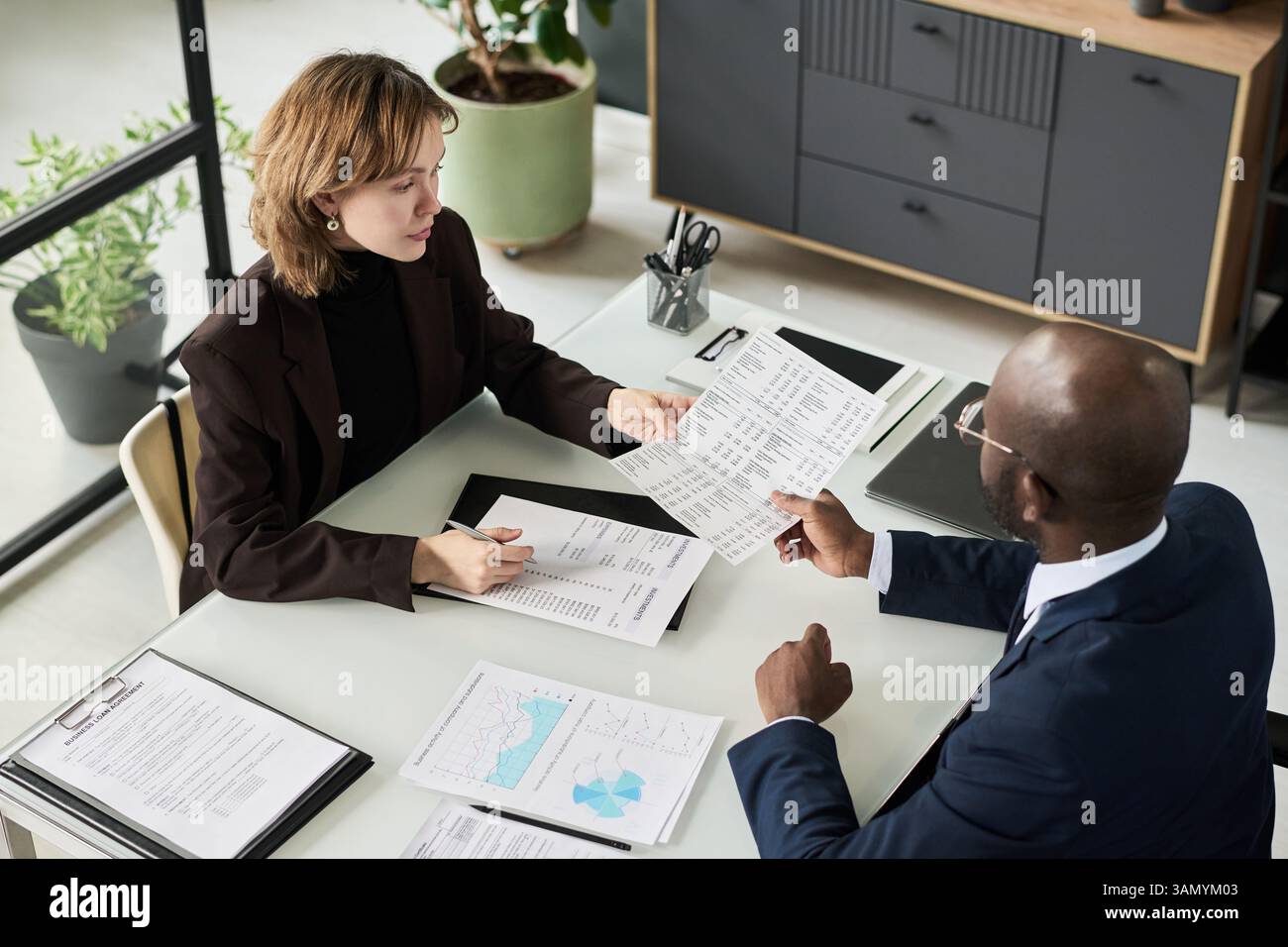 Colleagues Analyzing Financial Documents At Meeting Stock Photo