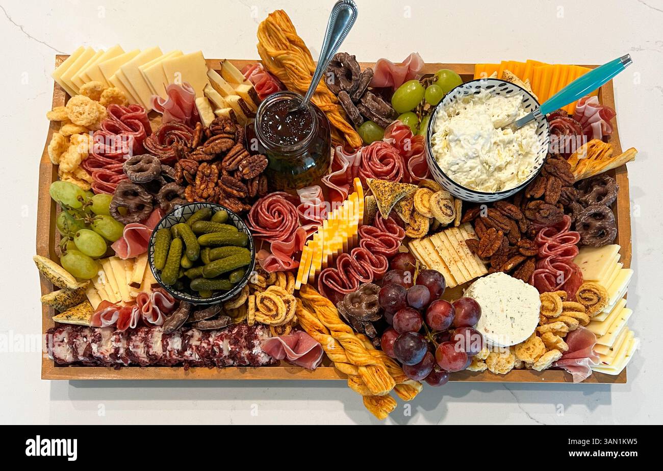 A perfectly arranged charcuterie board filled with artisan meats, cheeses, olives, dips, and sweet treats for the ultimate snacking experience. - Smartphone Captured Stock Image