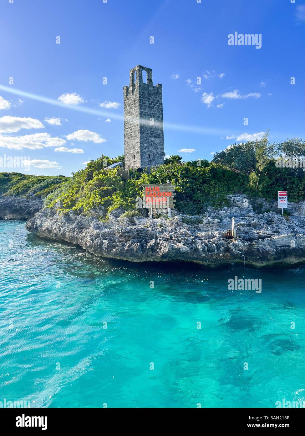 Blue Lagoon Island offers breathtaking views, crystal-clear waters, and rich history. This stone tower stands as a landmark against the lush greenery - Smartphone Captured Stock Image