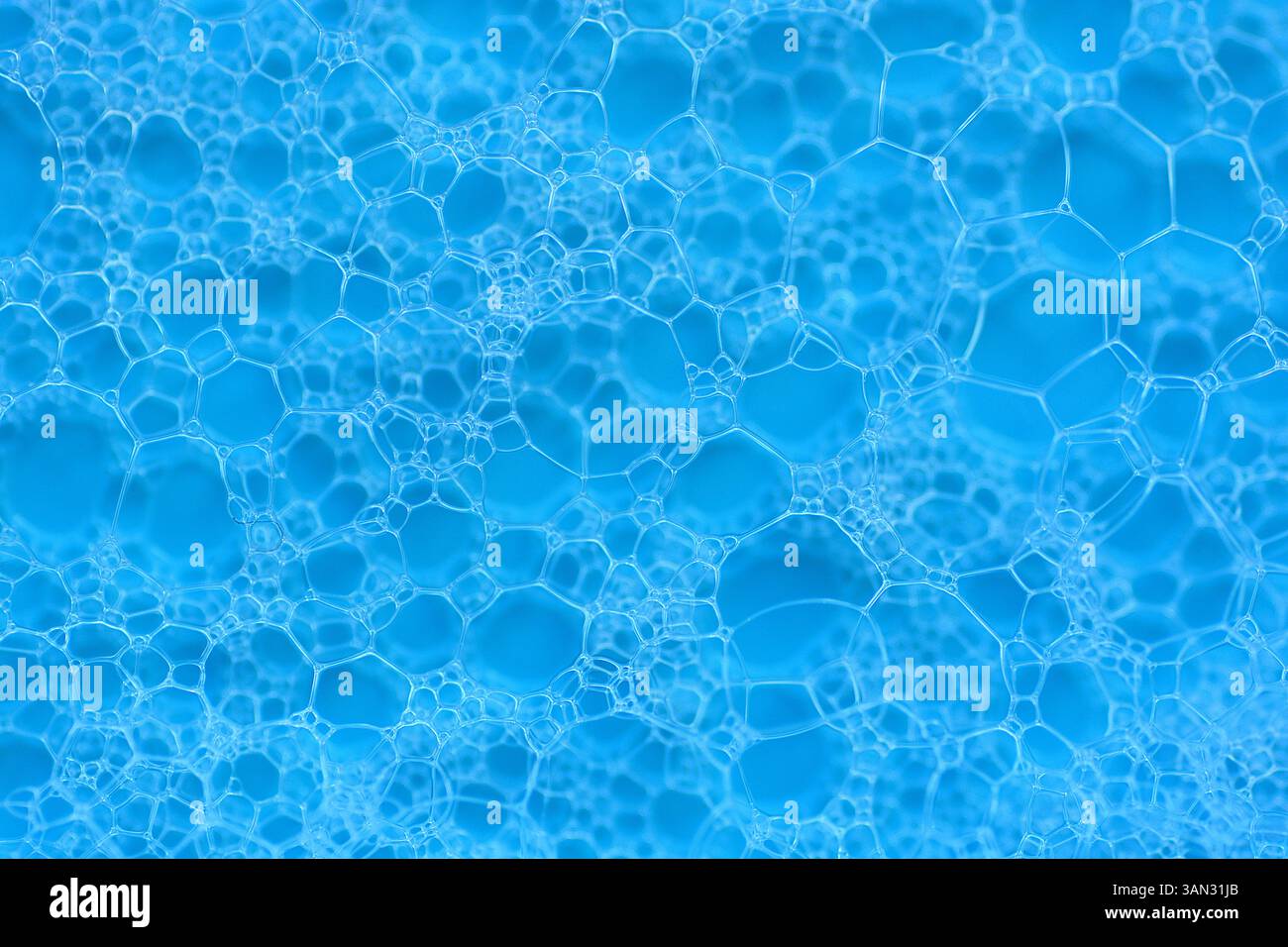 White soap bubbles abstract pattern foam texture on blue background. Stock Photo