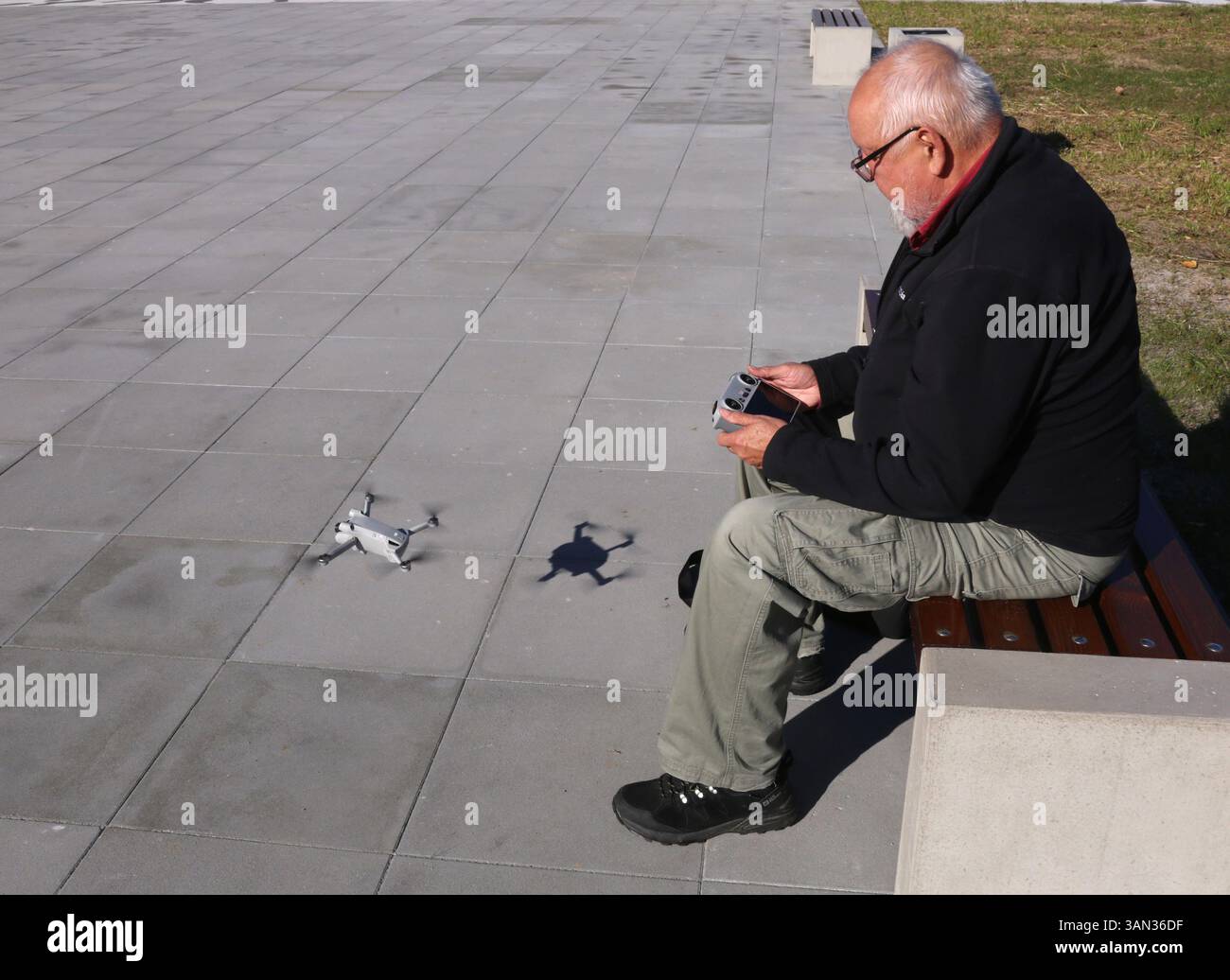 Cracow. Krakow. Poland. Old man operating aerial photography drone with remote controller. Stock Photo