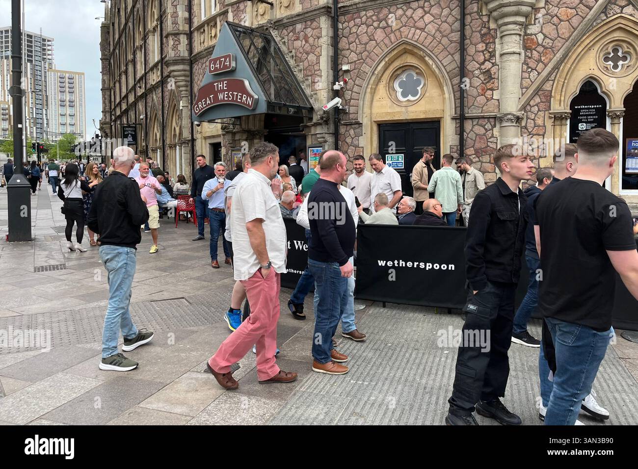 People walking past while patrons drink outside a Wetherspoons called The Great Western near Cardiff Central Station. Cardiff, Wales, United Kingdom. - Smartphone Captured Stock Image People walking past while patrons drink outside a Wetherspoons called The Great Western near Cardiff Central Station. Cardiff, Wales, United Kingdom. - Smartphone Captured Stock Image