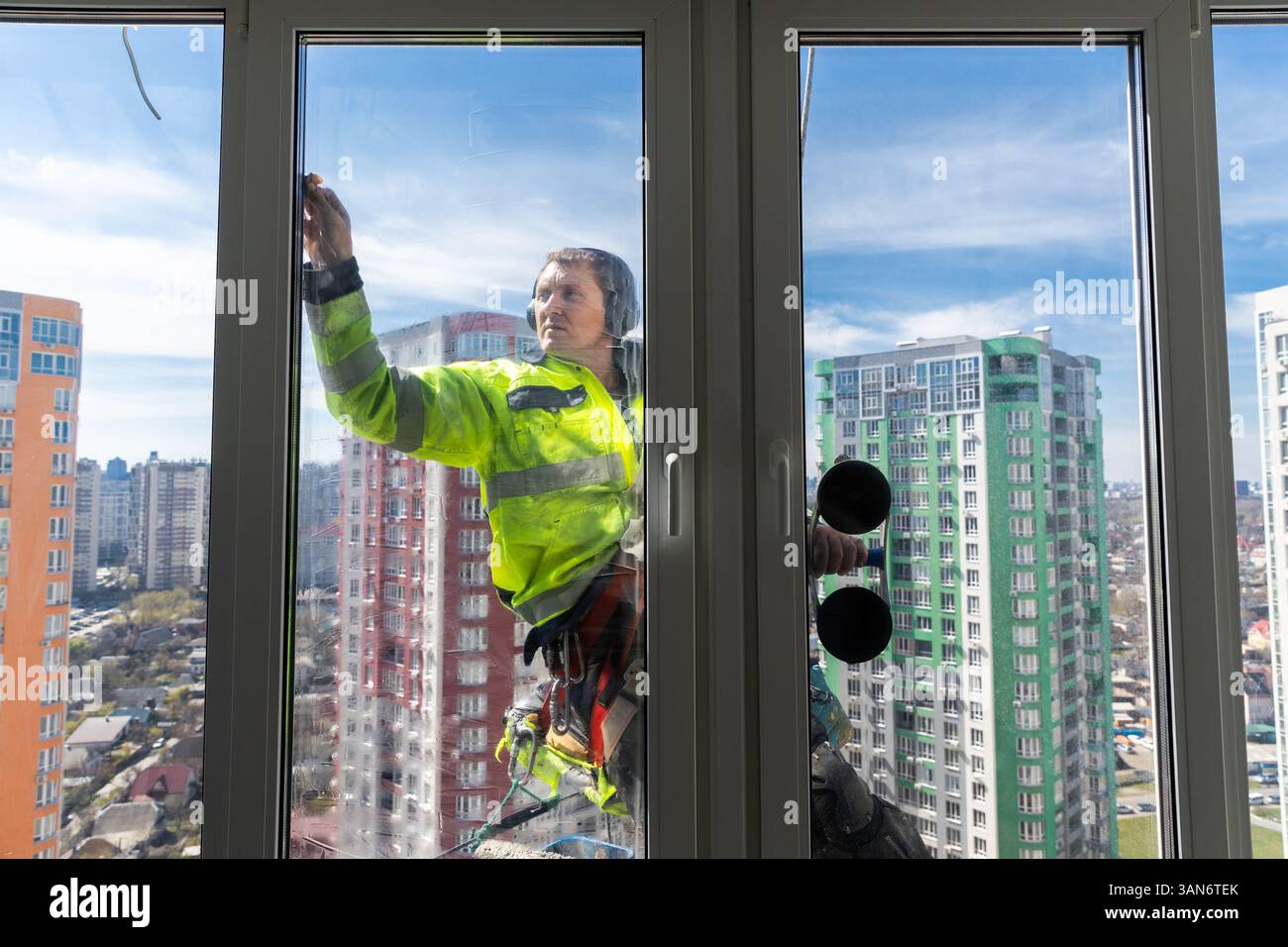 Professional Window Cleaner Performing Glass Maintenance on a High-Rise ...