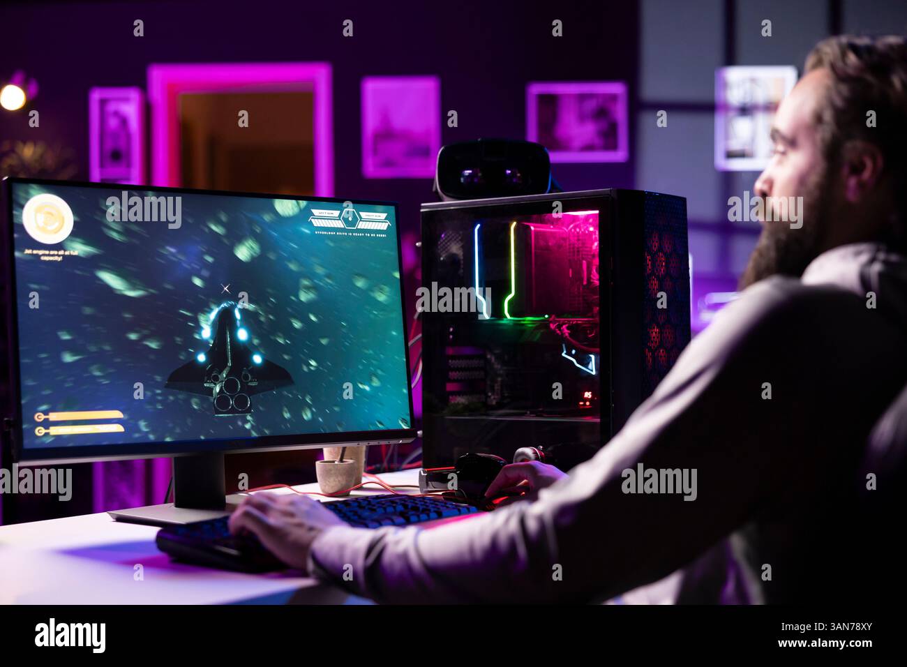 Man having fun by using gaming keyboard to fly spaceship in SF ...