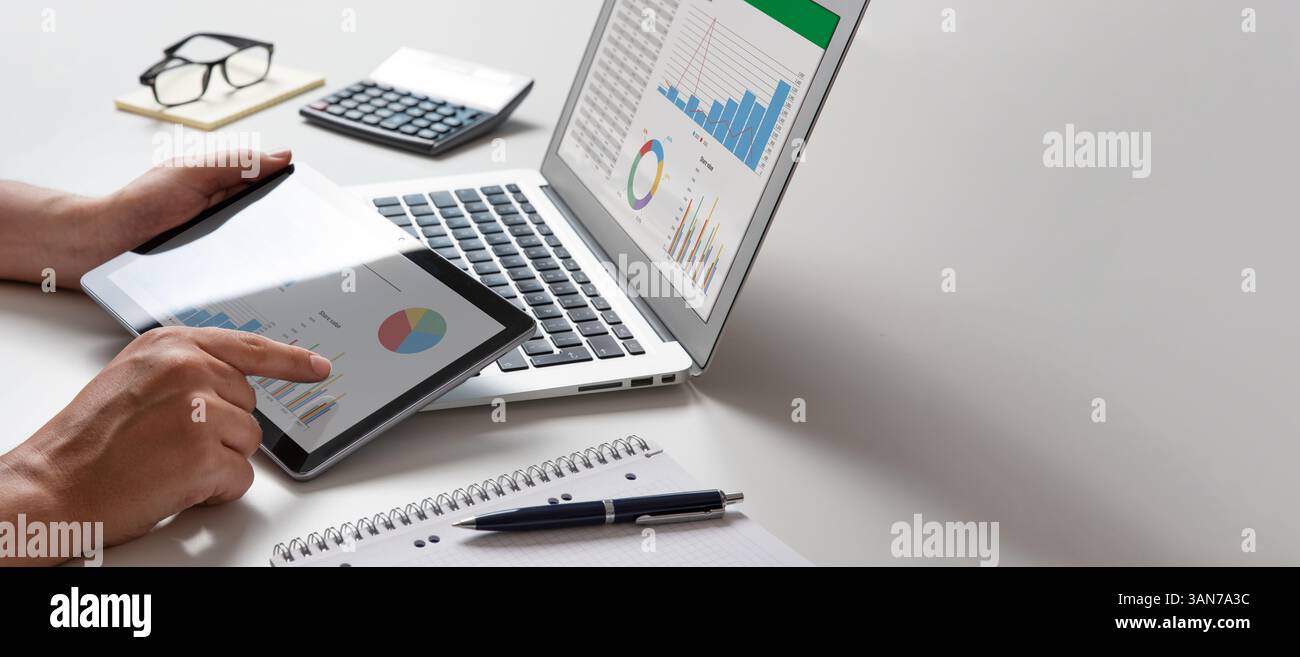 Man using tablet and laptop, financial app. Analyst at work Stock Photo