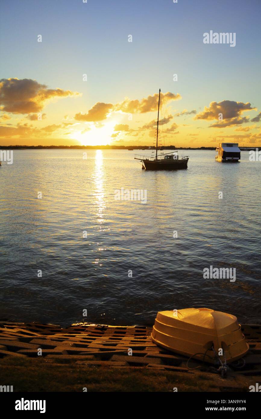 Up turned dinghy on the shore as the sun rises over the water Stock ...