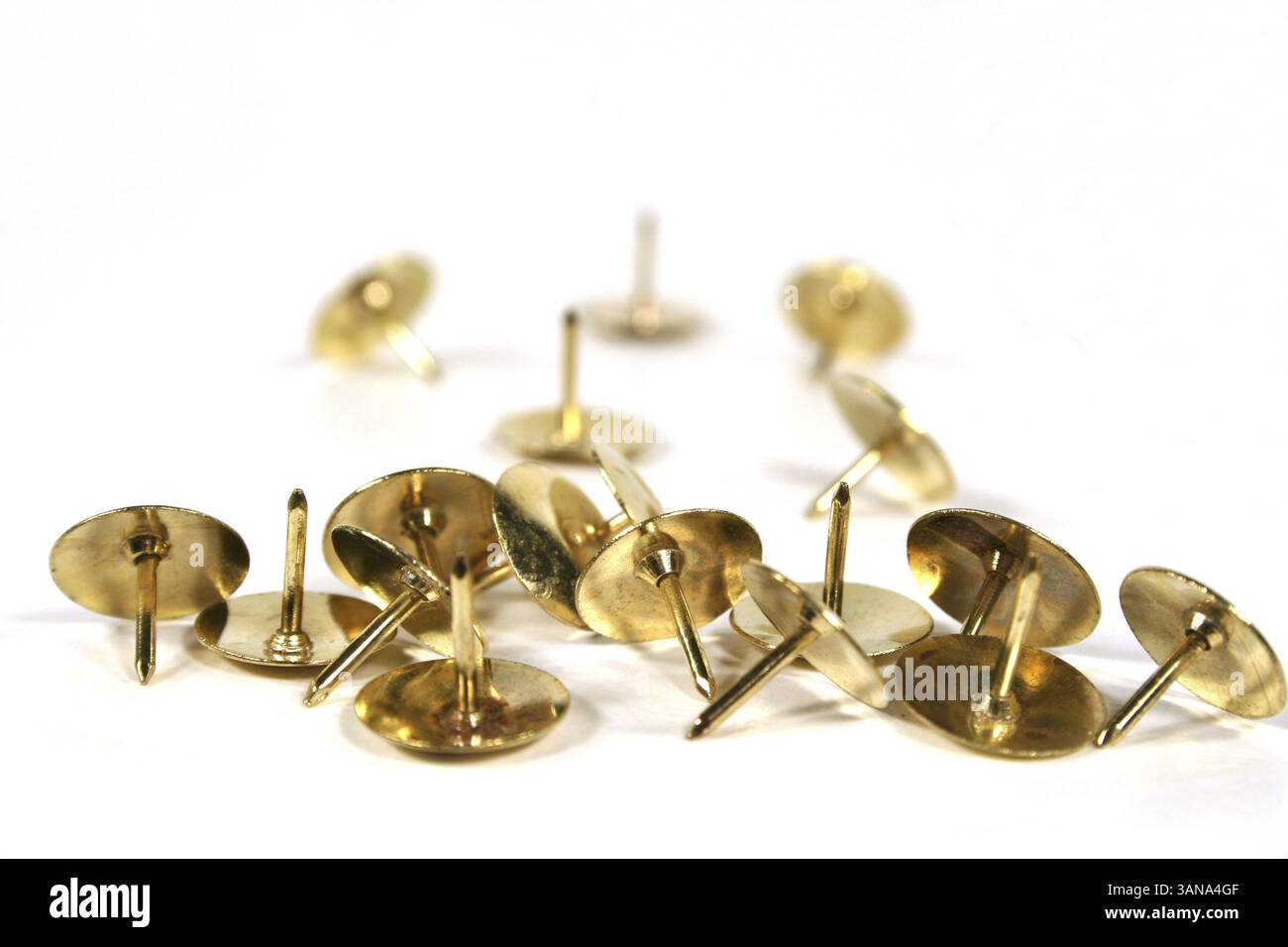 Scattered thumb tacks isolated on a white background Stock Photo