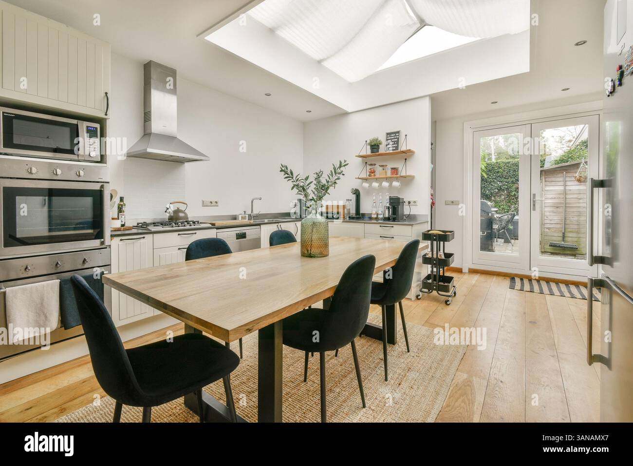 A bright and airy modern kitchen featuring a dining table, sleek ...