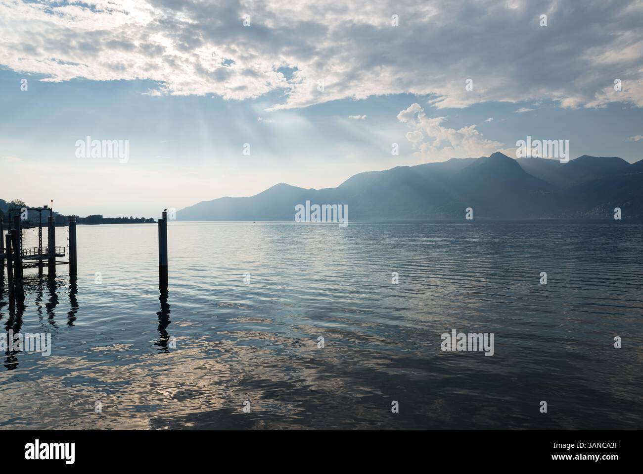 Sun rays filtering through the clouds over the water. Lake Maggiore ...
