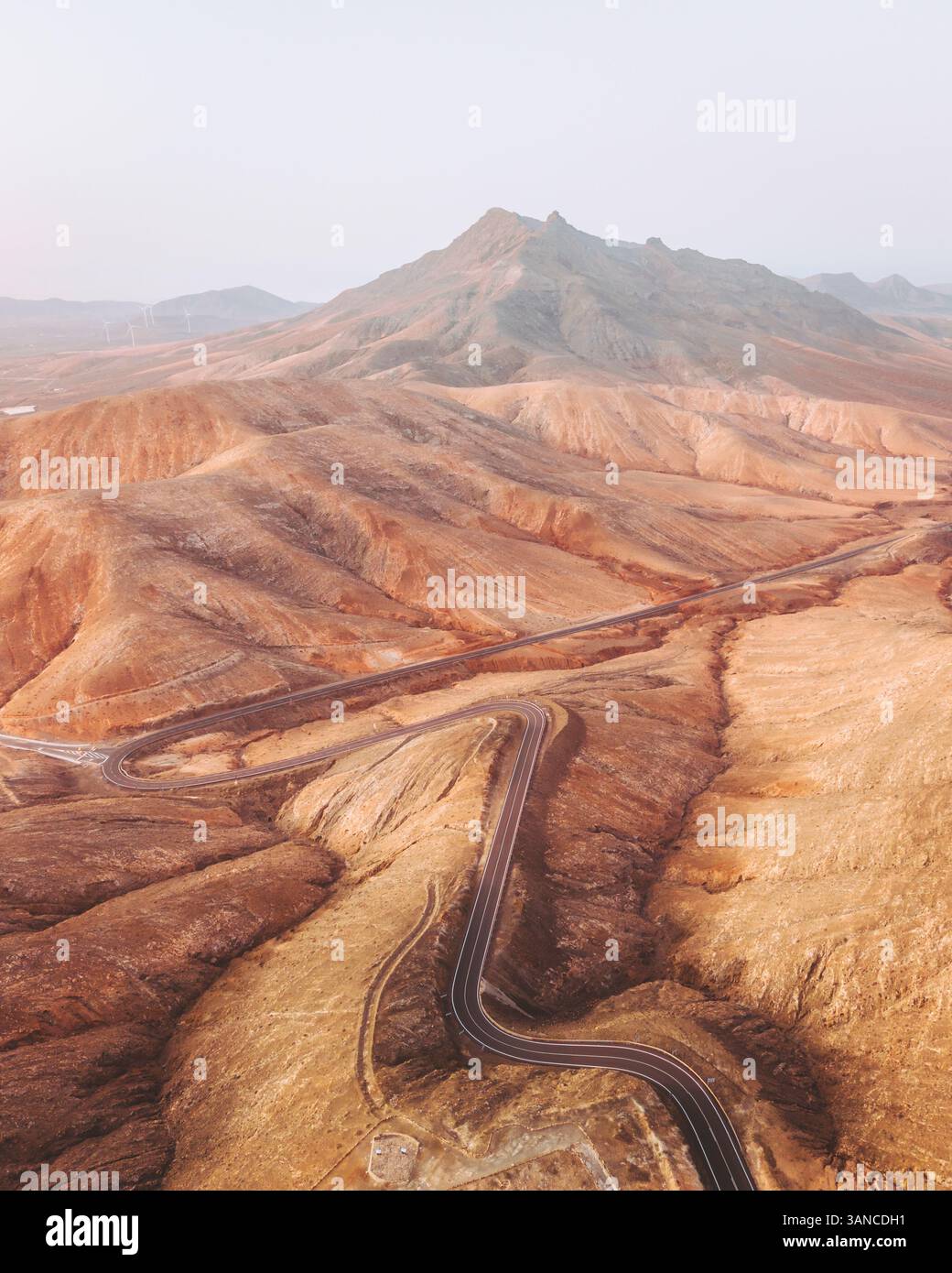 Aerial view of winding road through rocky hills and desert landscape ...