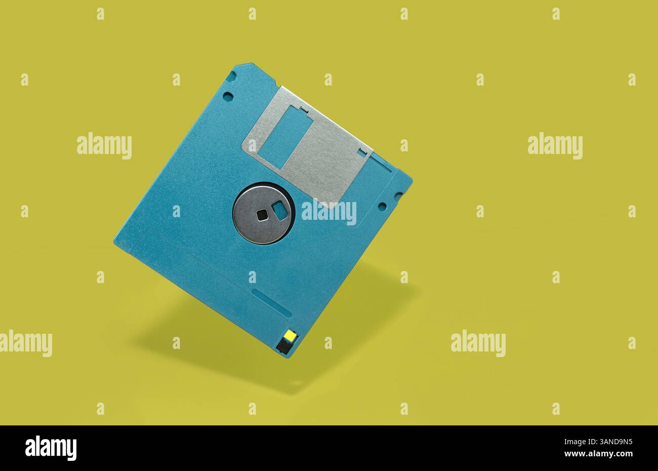 Vibrant Blue Floppy Disk on Minimalistic Yellow Background Stock Photo