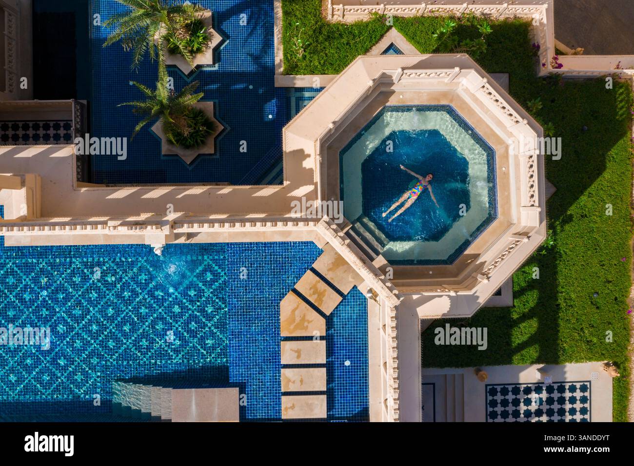 Aerial view of a woman relaxing in a swimming pool in a luxury hotel in ...