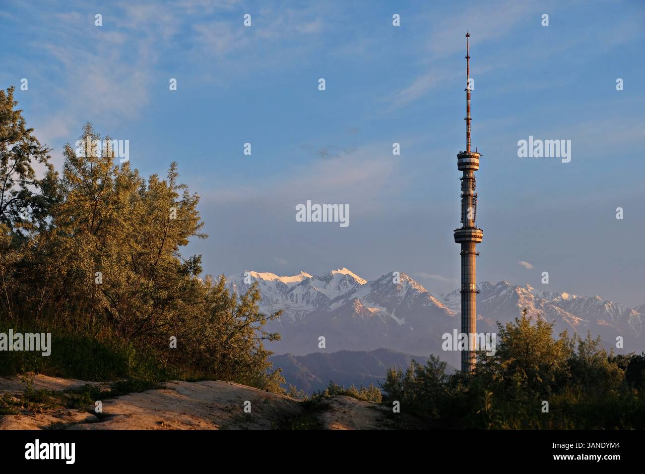 Kok Tobe TV tower, located on a high hill with trees above the city of ...