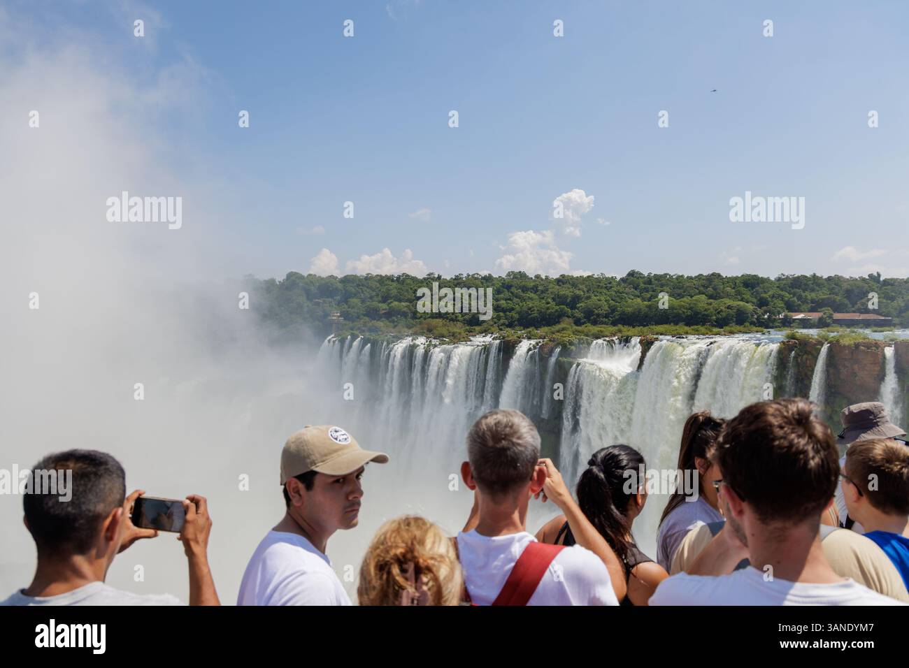 Puerto Iguazu, Misiones, Argentina - April 5th, 2025: Tourists watching the Devil's Throat waterfall at Iguazu Falls. Stock Photo