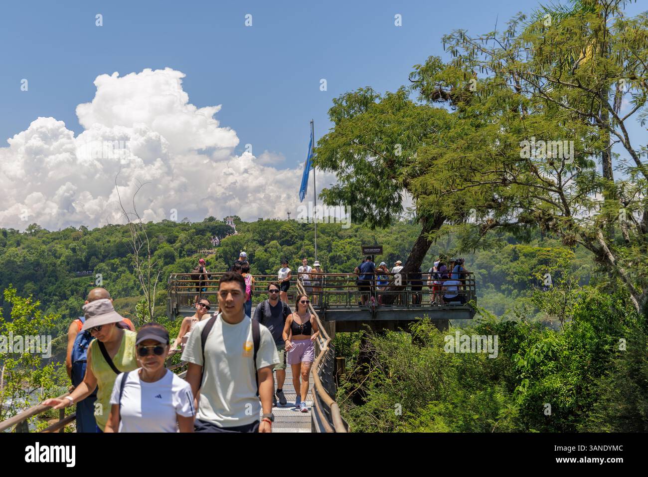 Puerto Iguazu, Misiones, Argentina - April 5th, 2025: Tourists trucking along the Iguazu National Park walkways. Stock Photo