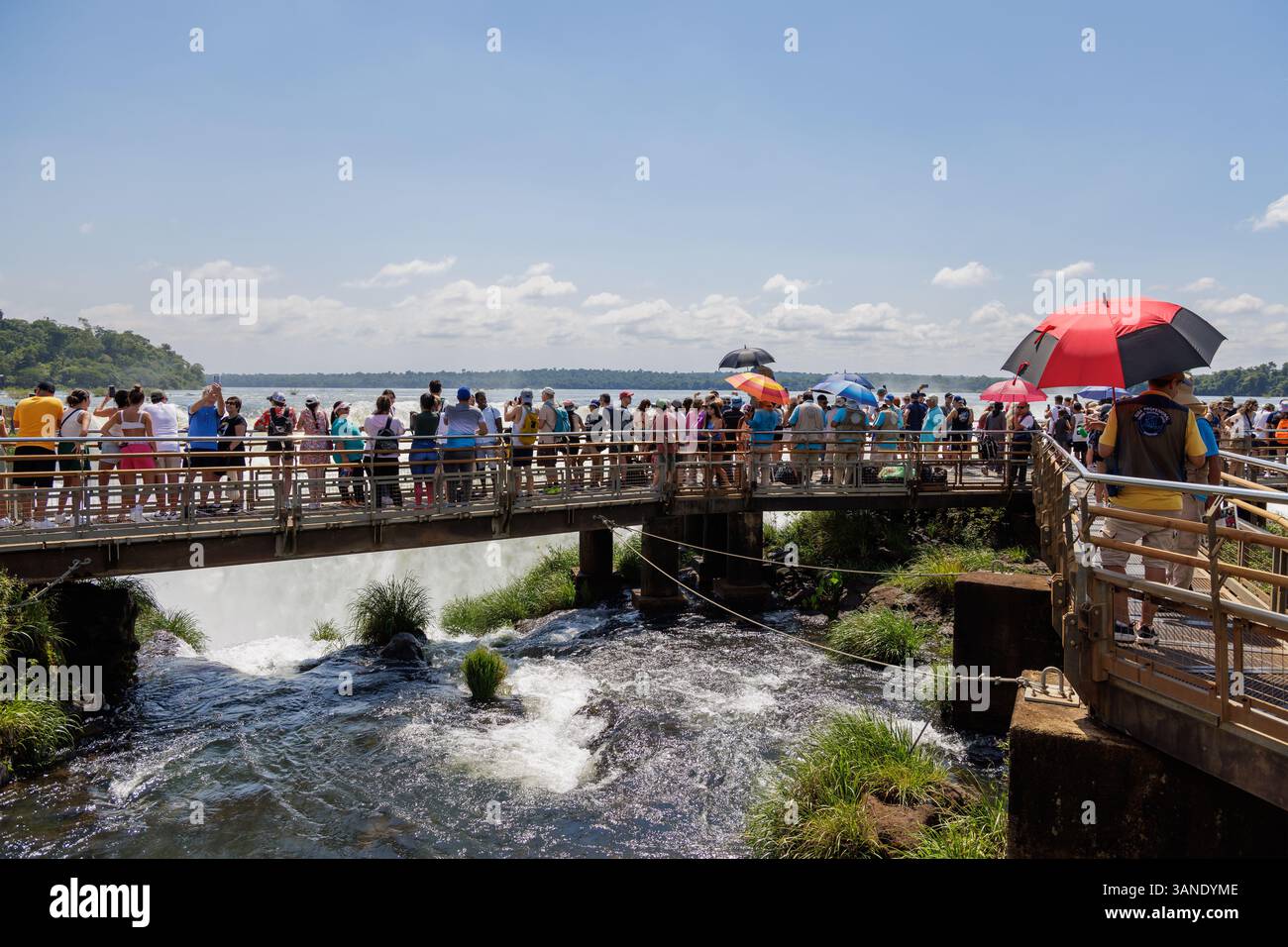 Puerto Iguazu, Misiones, Argentina - April 5th, 2025: Tourists watching the Devil's Throat waterfall at Iguazu Falls. Stock Photo