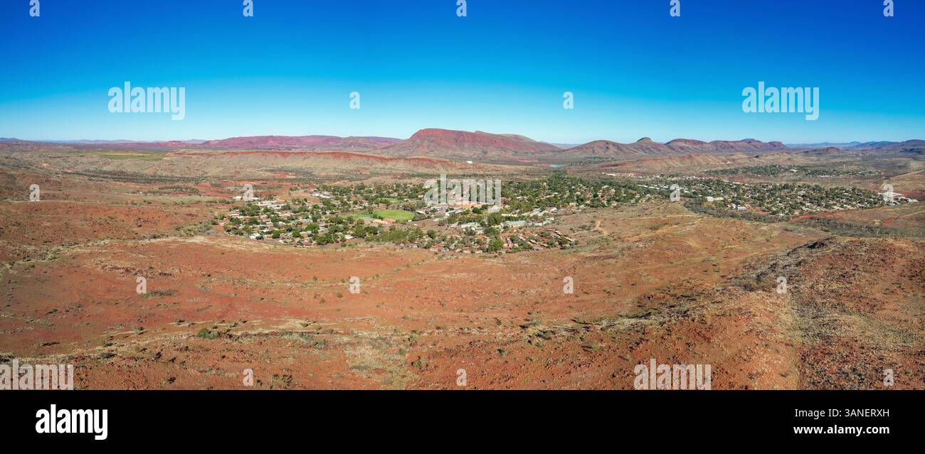 Aerial view of rugged mountains and a vast valley under a clear sky ...