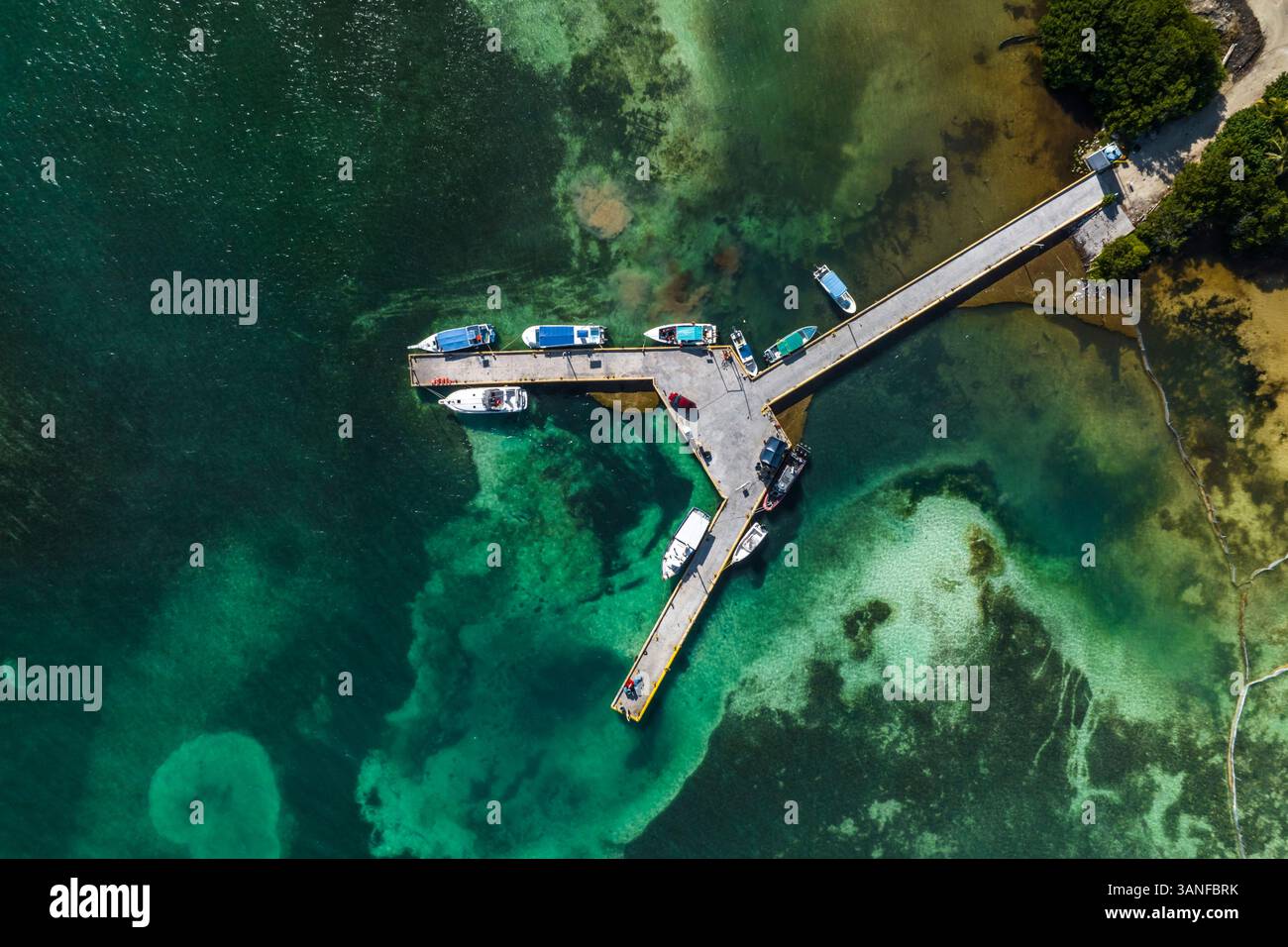 Aerial view of boats moored along a small pier along the coastline ...