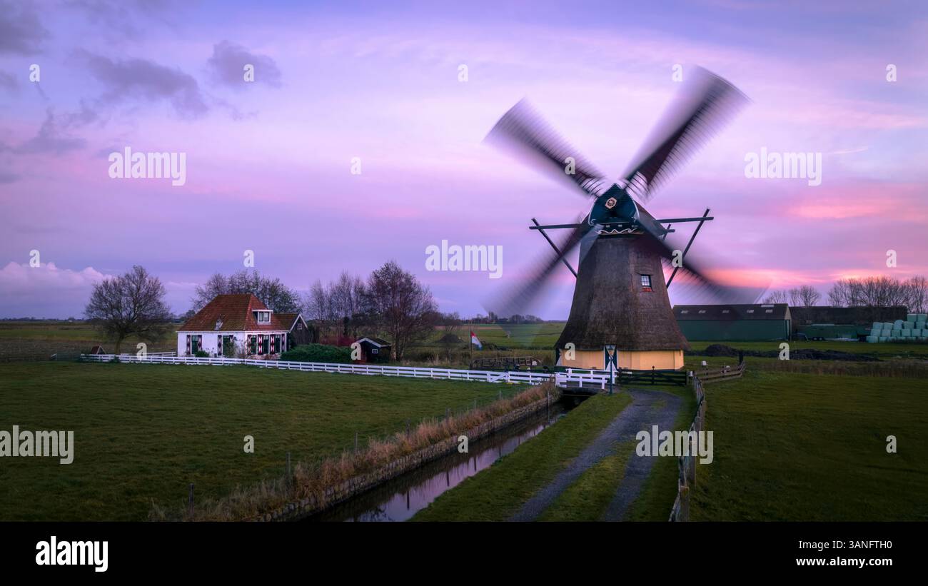 Aerial view of a beautiful traditional windmill at sunrise surrounded