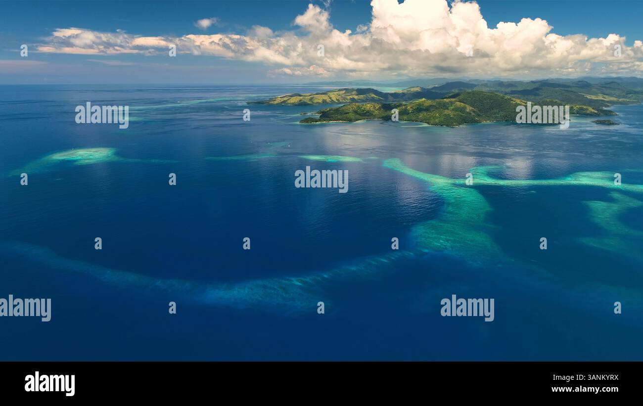 Aerial view of tropical island with reef and clouds, Northern Fiji ...