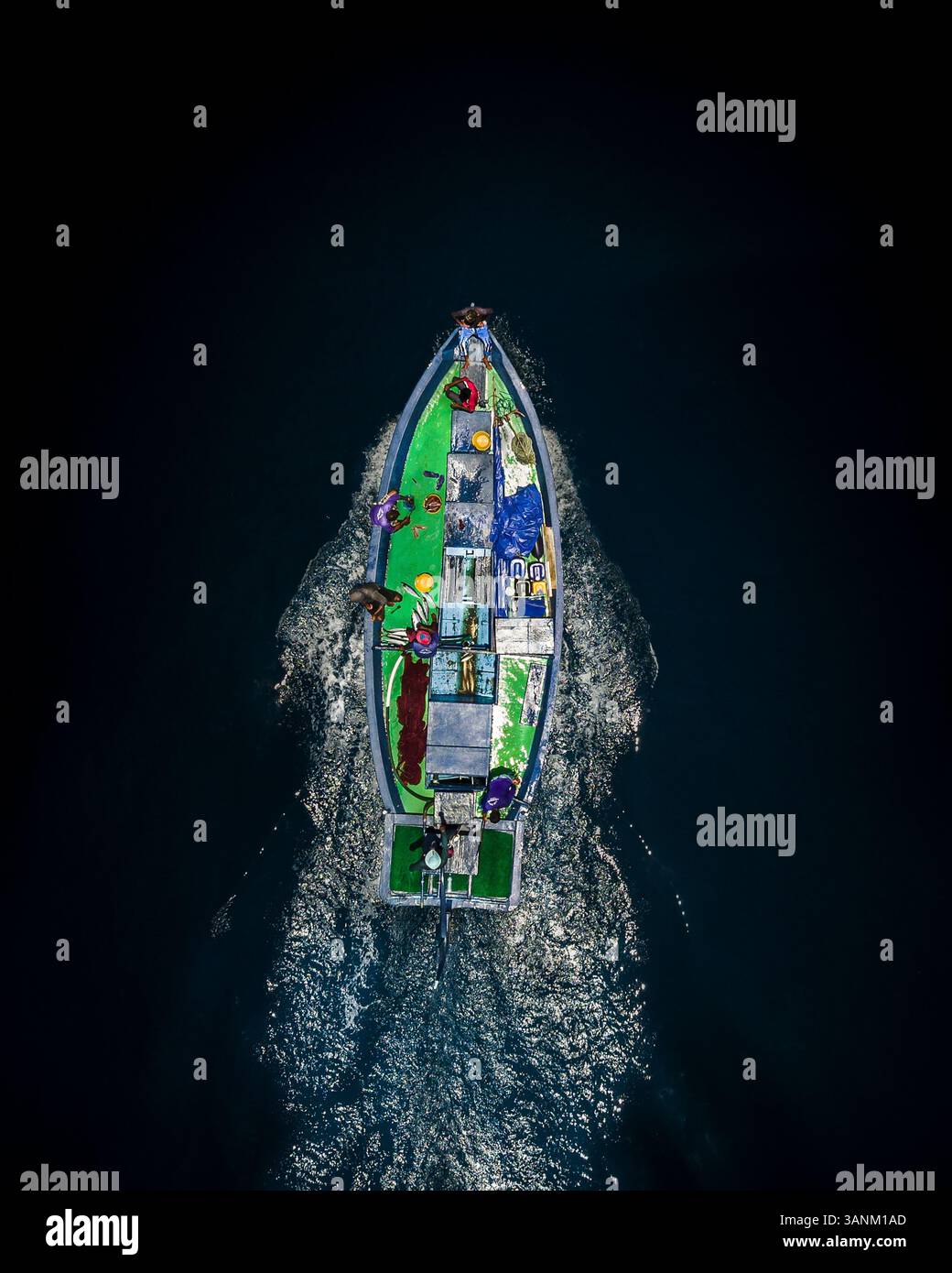 Aerial view of a traditional fishing boat cruising through the ocean in ...