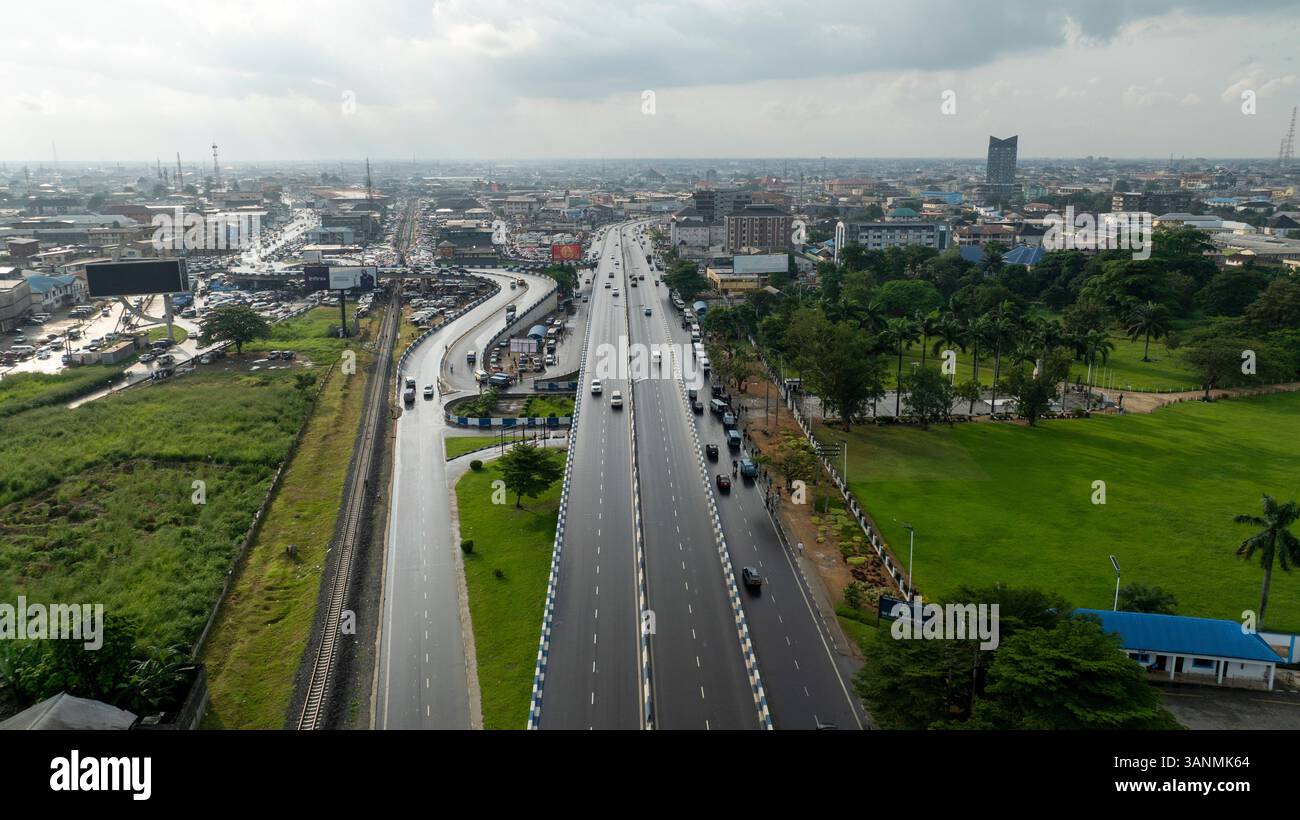 Aerial View Of A Modern Bridge Above A Busy Cityscape With Greenery And aerial-view-of-a-modern-bridge-above-a-busy-cityscape-with-greenery-and