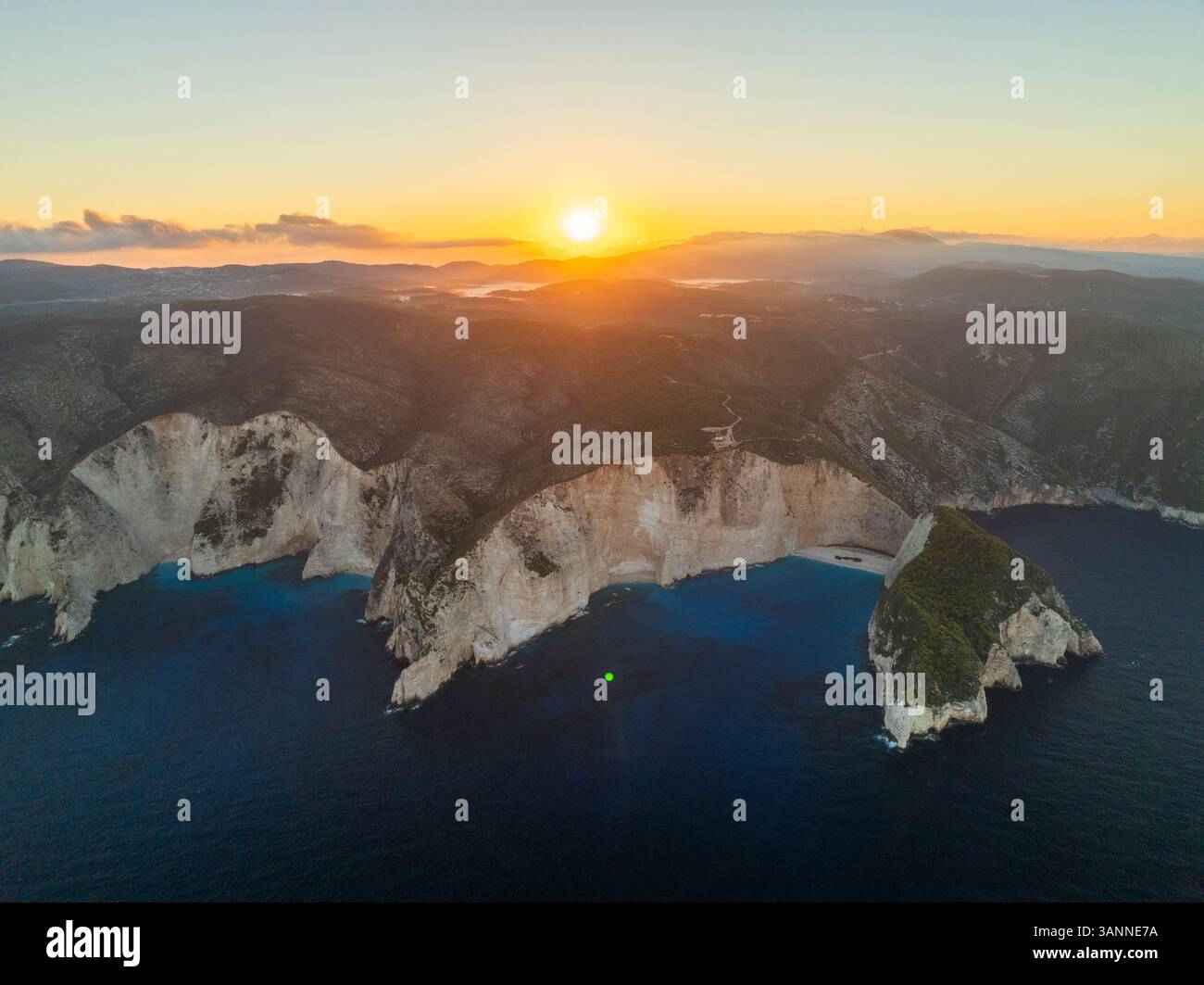 Aerial view of rugged cliffs and serene sea at sunset, Volimes, Greece. Stock Photo