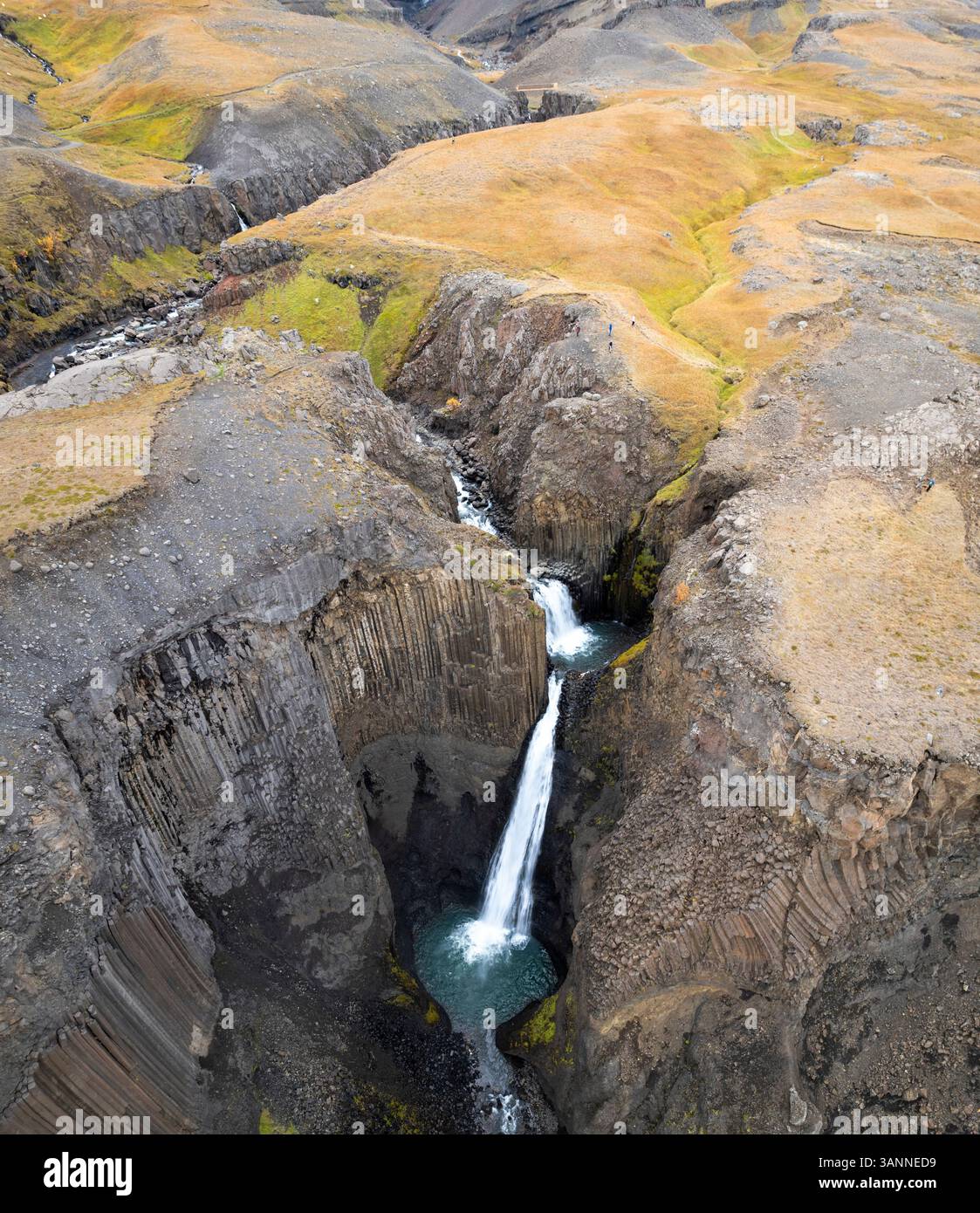 Aerial view of a breathtaking waterfall cascading through a majestic ...