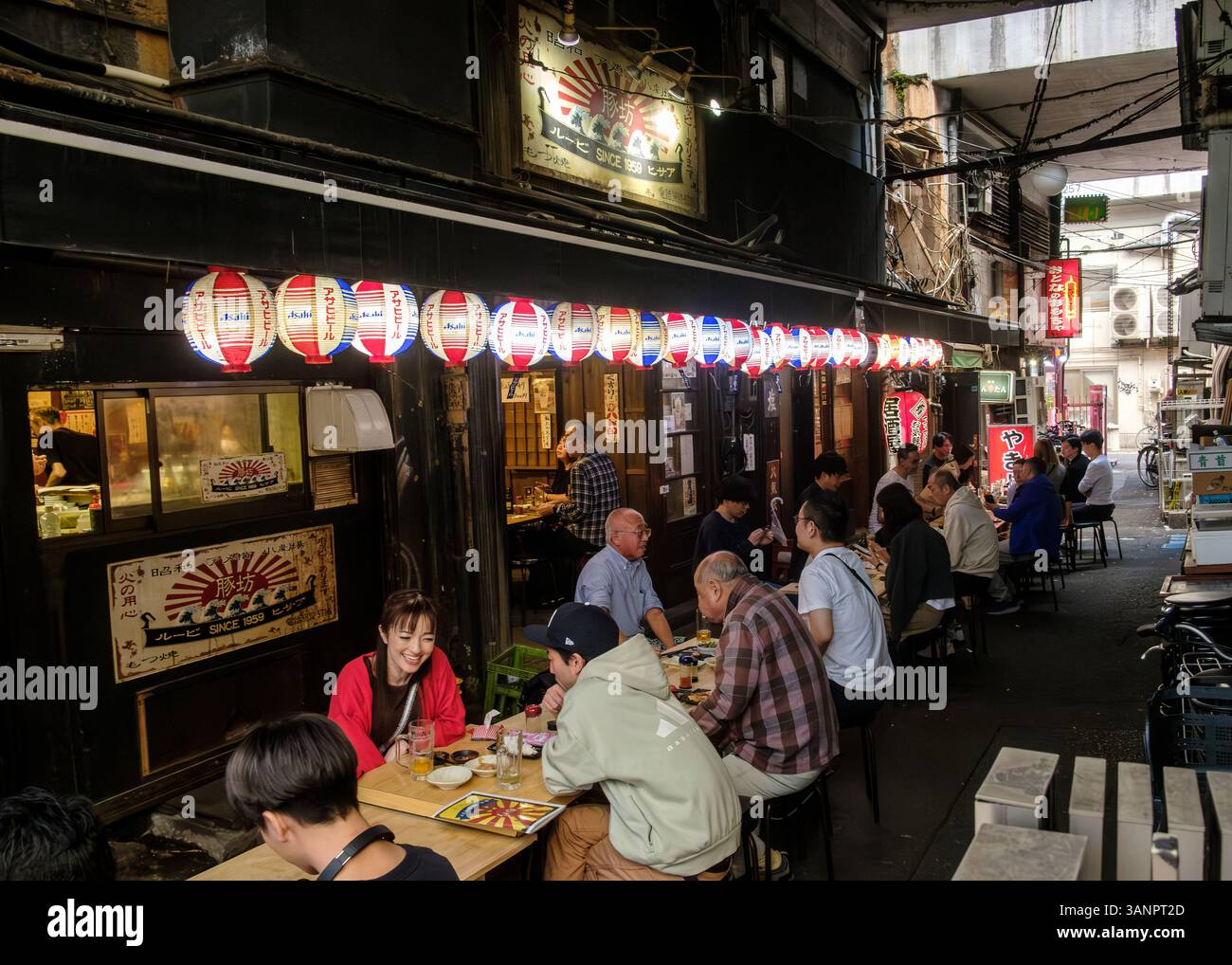 People eating in an Izakaya restaurant under the railway lines at Ameyoko shopping street, Ueno, Tokyo Stock Photo