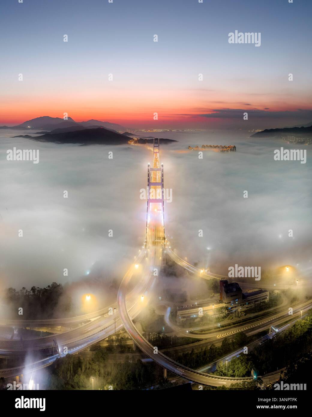 Aerial view of Tsing Ma Bridge at sunset with low clouds in Hong Kong ...