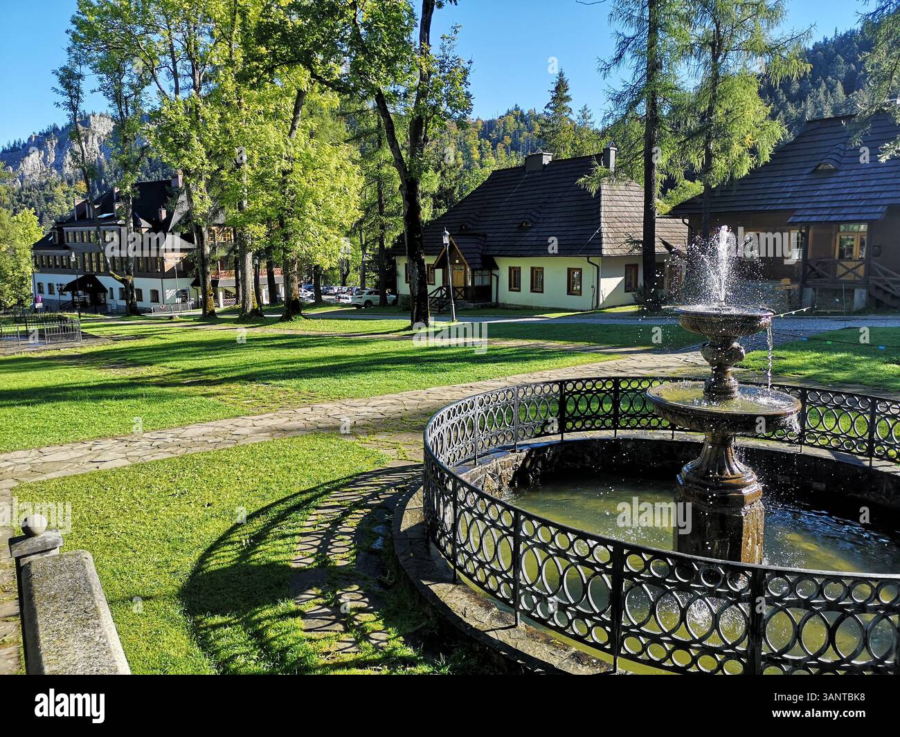 Beautiful wooden and traditional architecture of Kuznice village near Zakopane in southern Poland with scenic fountain. - Smartphone Captured Stock Image
