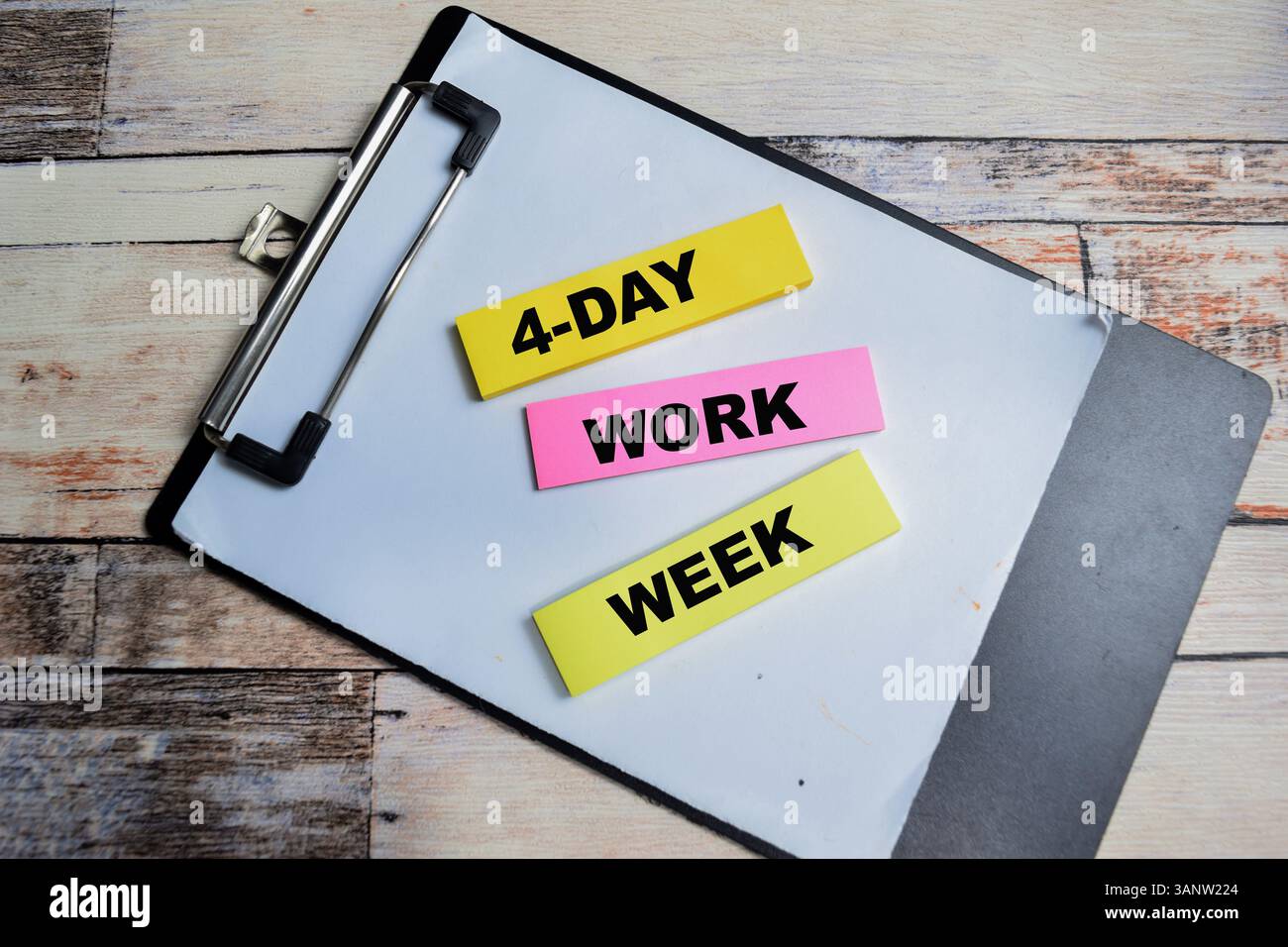 Concept of 4 Day Work Week write on sticky notes isolated on Wooden Table. Stock Photo