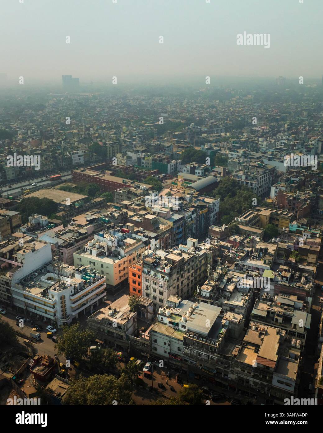 Aerial view of dense urban buildings and rooftops with a busy road ...