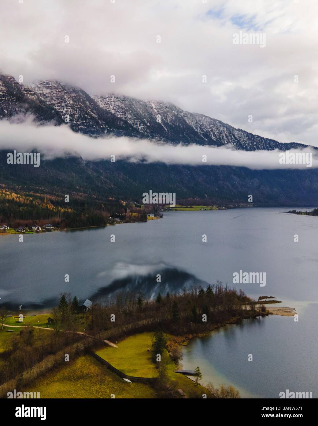 Aerial view of snow-capped mountains and a frozen lake with low clouds, Bad Goisern, Austria. Stock Photo