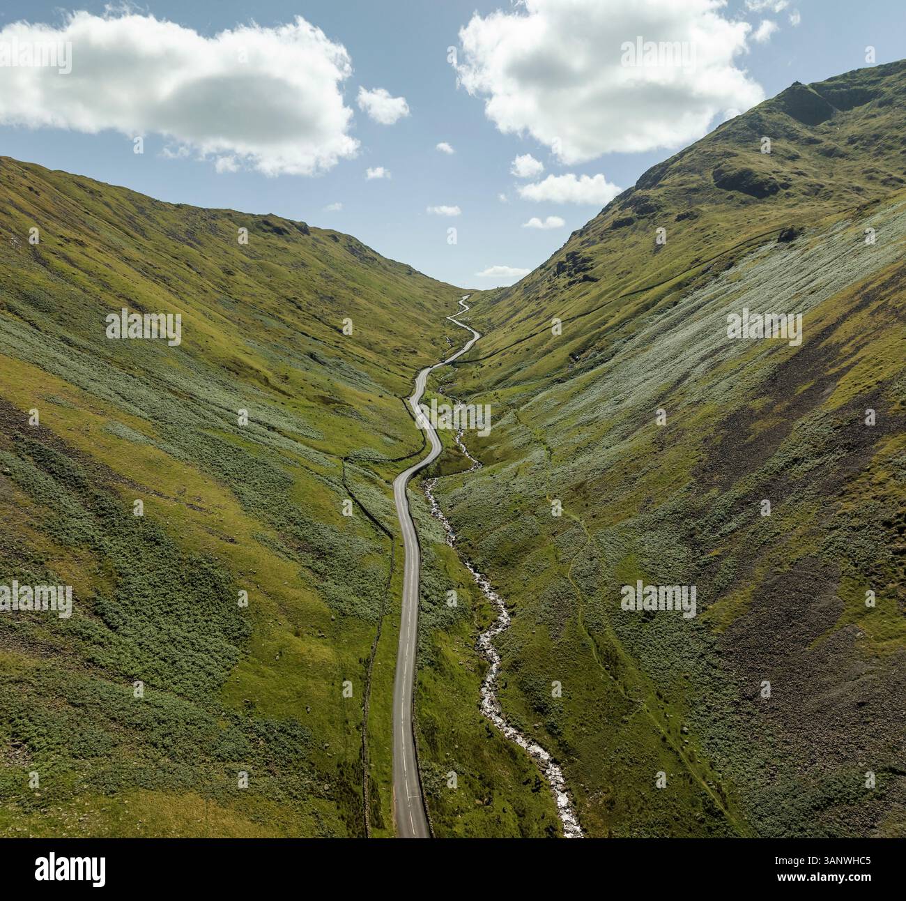 Aerial view of winding road through a beautiful valley surrounded by ...