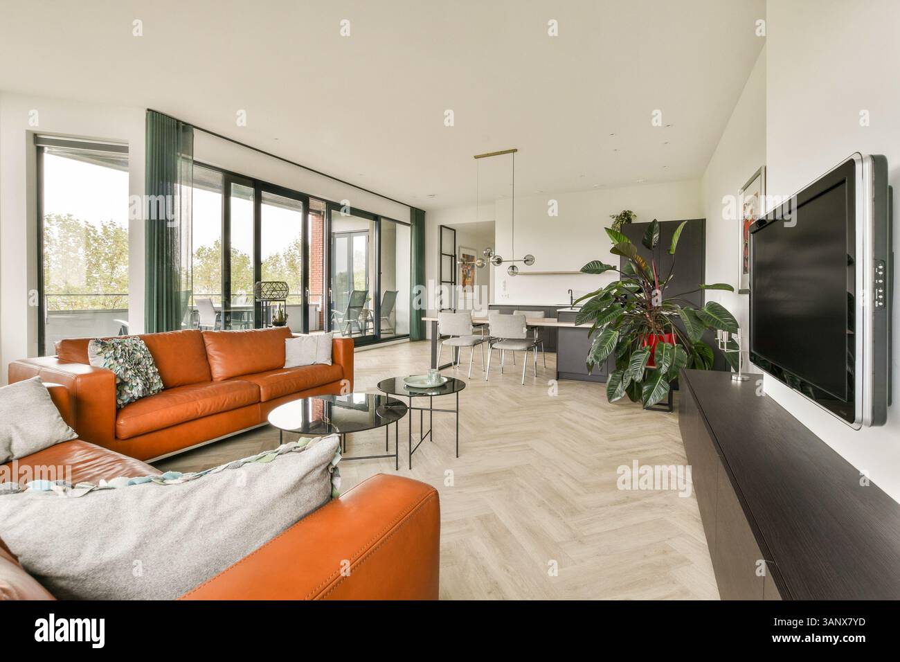 A stylish modern living room featuring an open layout, large windows ...