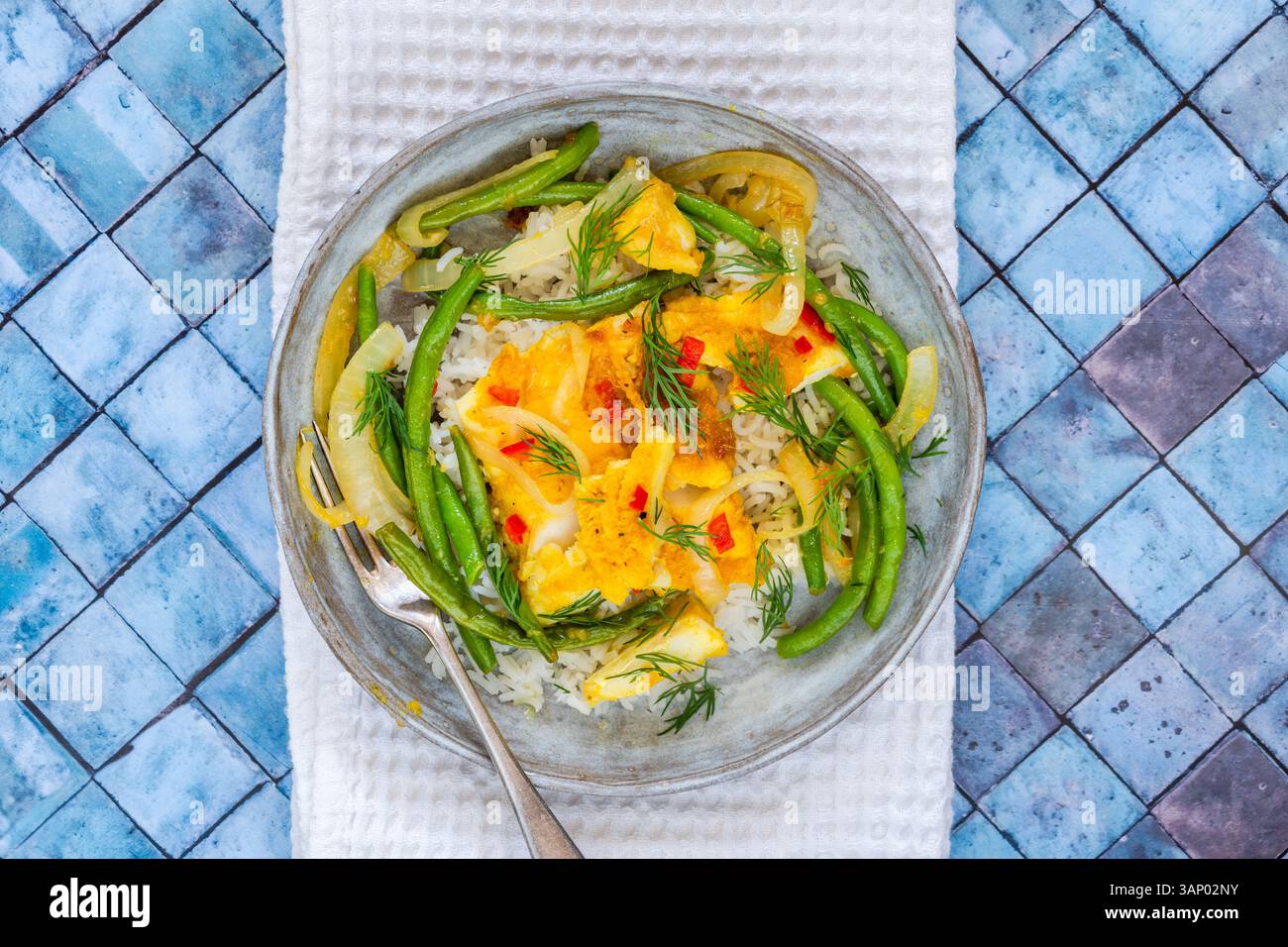 Ginger and turmeric cod with green beans and rice Stock Photo
