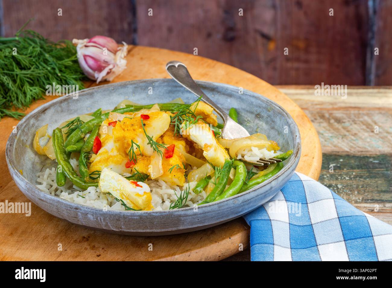 Ginger and turmeric cod with green beans and rice Stock Photo