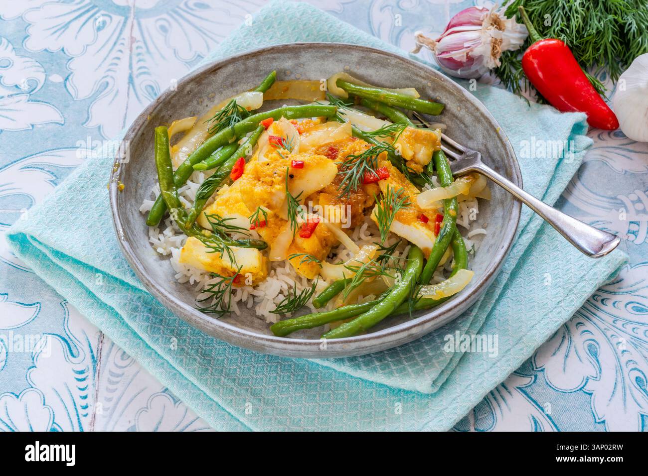 Ginger and turmeric cod with green beans and rice Stock Photo