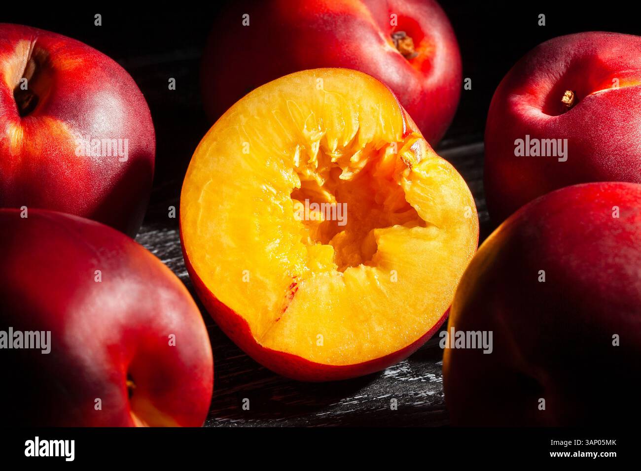 sliced nectarine on black wood background Stock Photo