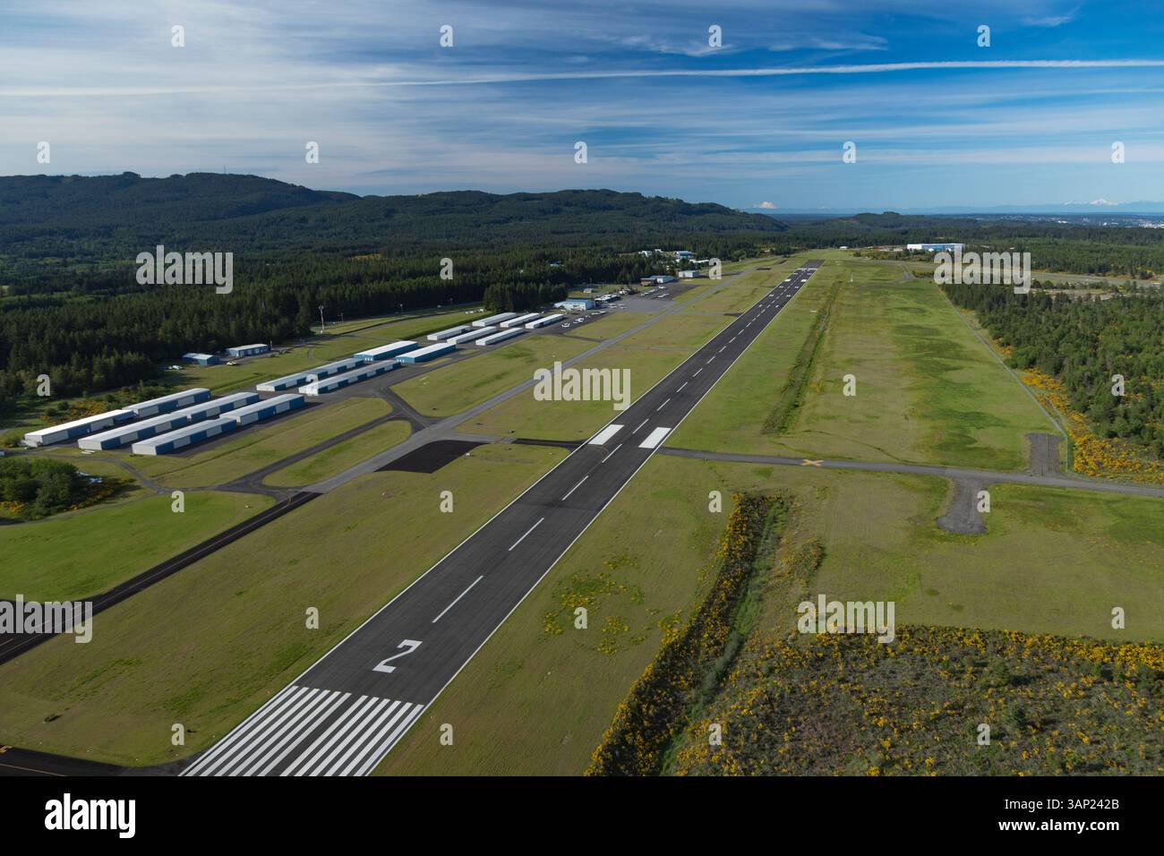 Aerial view of Bremerton National Airport with runway and hangars surrounded by serene greenery and forest, Bremerton, Washington, United States. Stock Photo