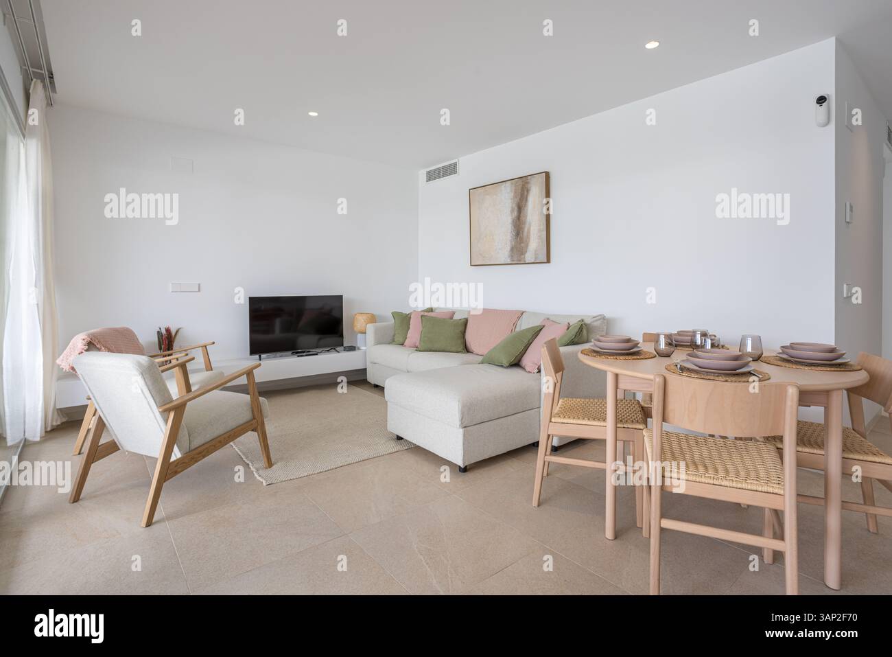 Bright living room with soft beige tones, pastel pillows, and a wooden ...
